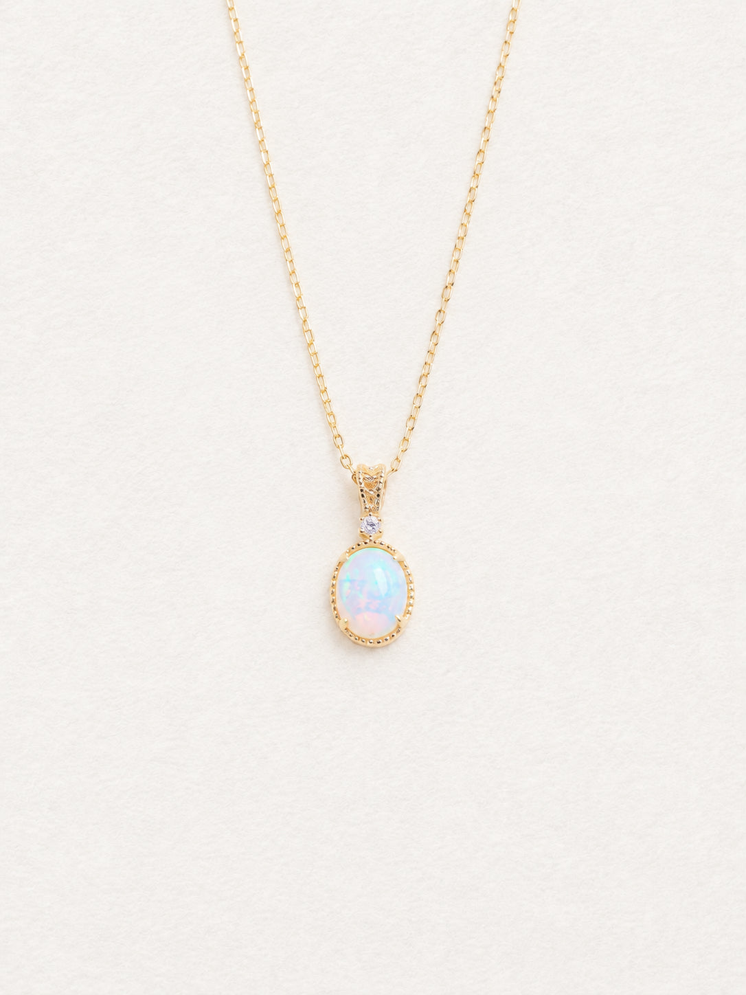 LUMERUNE Lunar Opal Starlight Pendant — oval opal in a gold toned setting with a white zircon
