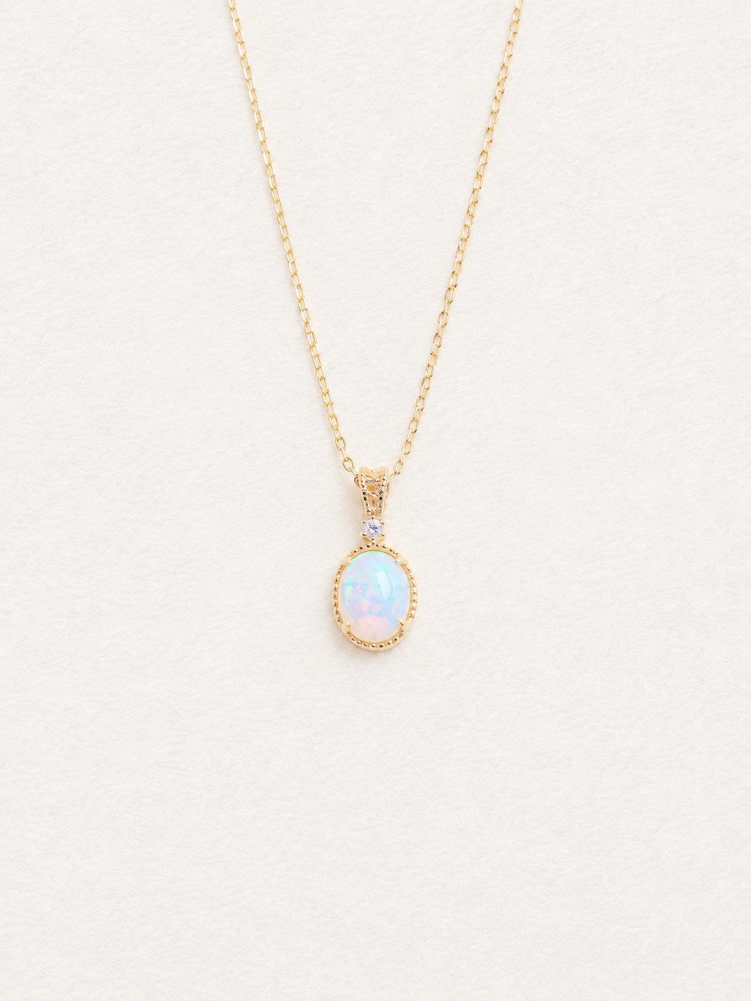LUMERUNE Lunar Opal Starlight Pendant — oval opal in a gold toned setting with a white zircon