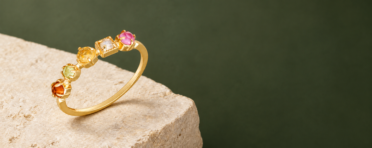Bonbon Multi-Gemstone Ring on cream limestone against a deep sage background